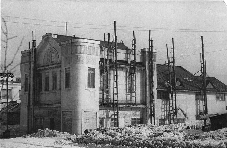 Здание. Слева у обреза виден торцевой фасад гостиницы 'Дальневосточник' г. Южно-Сахалинск. На стремянках сборные керамический печные трубы.